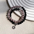 Black obsidian and pink cat eye double wrap bracelet displayed to symbolize protection, love