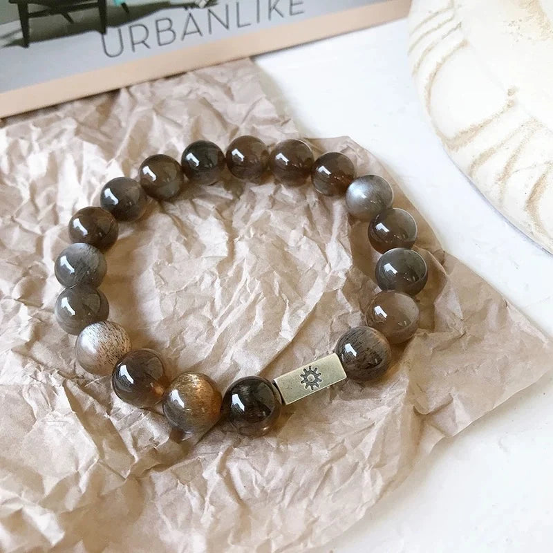Bracelet moonstone with celestial charms, promoting inner calm, intuition, and cosmic alignment