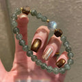 Green rutile quartz bracelet with grey moonstone and agarwood beads