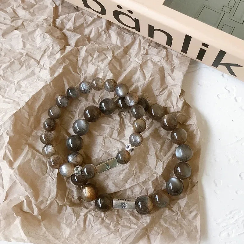 Moonstone bracelet featuring sun and moon charms, radiating chakra energy