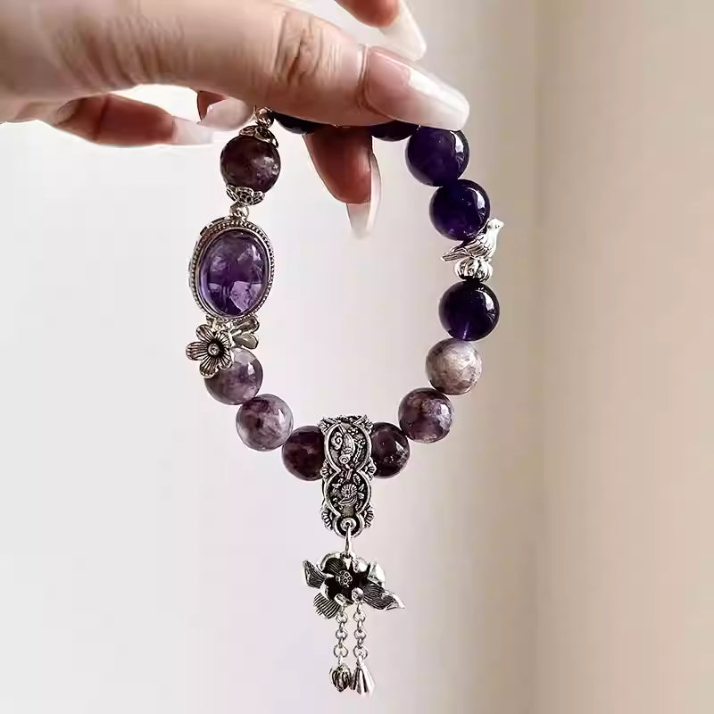 Purple amethyst bracelet featuring polished gemstones and crystals with an elegant style