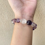 Woman wearing amethyst and clear quartz bracelet, calming crystal bracelets, stylish energy stone accessory for women.