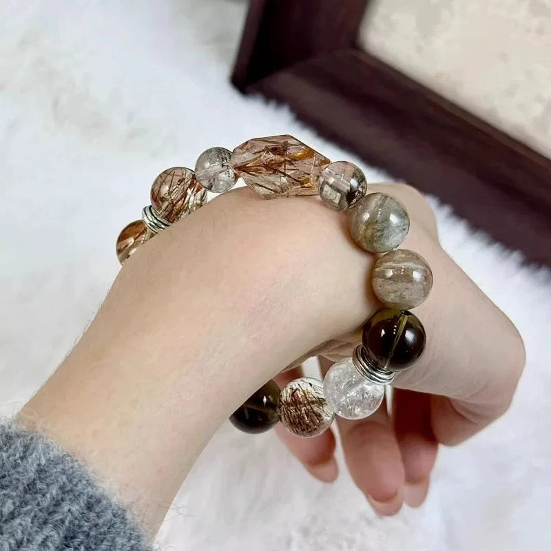 Black super seven and rutilated quartz bracelet, a spiritual accessory for power, energetic clarity, and abundance.