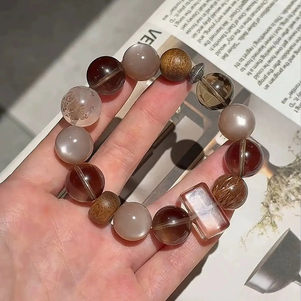Black Super Seven, moonstone, and smoky quartz bracelet, a healing crystal accessory promoting balance and protective energy.