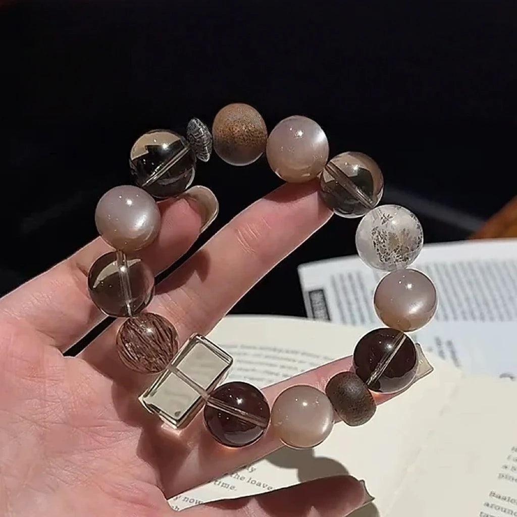 Artisan bracelet of black super seven, moonstone, and smoky quartz, designed to harmonize energy and safeguard the wearer.