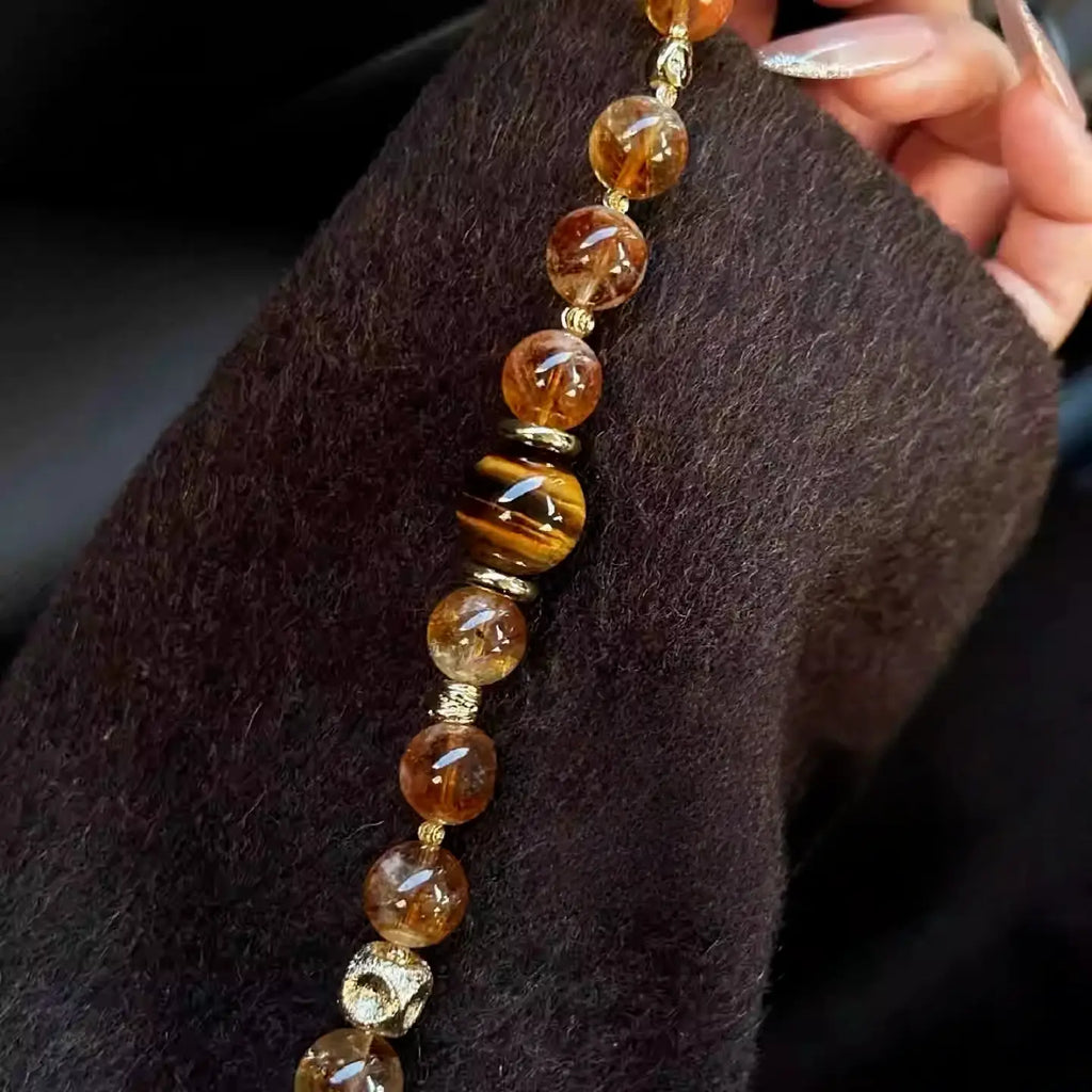 Natural citrine crystal bracelet combined with polished tiger eye stones in warm earthy tones.