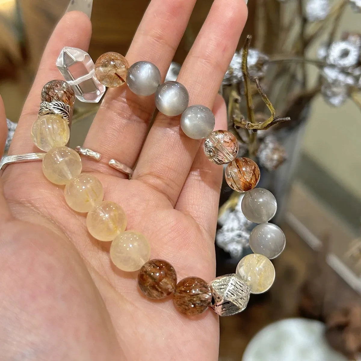 Elegant crystal bracelet with citrine flowers, moonstone, and gold obsidian beads, promoting prosperity, spiritual insight, and personal protection.