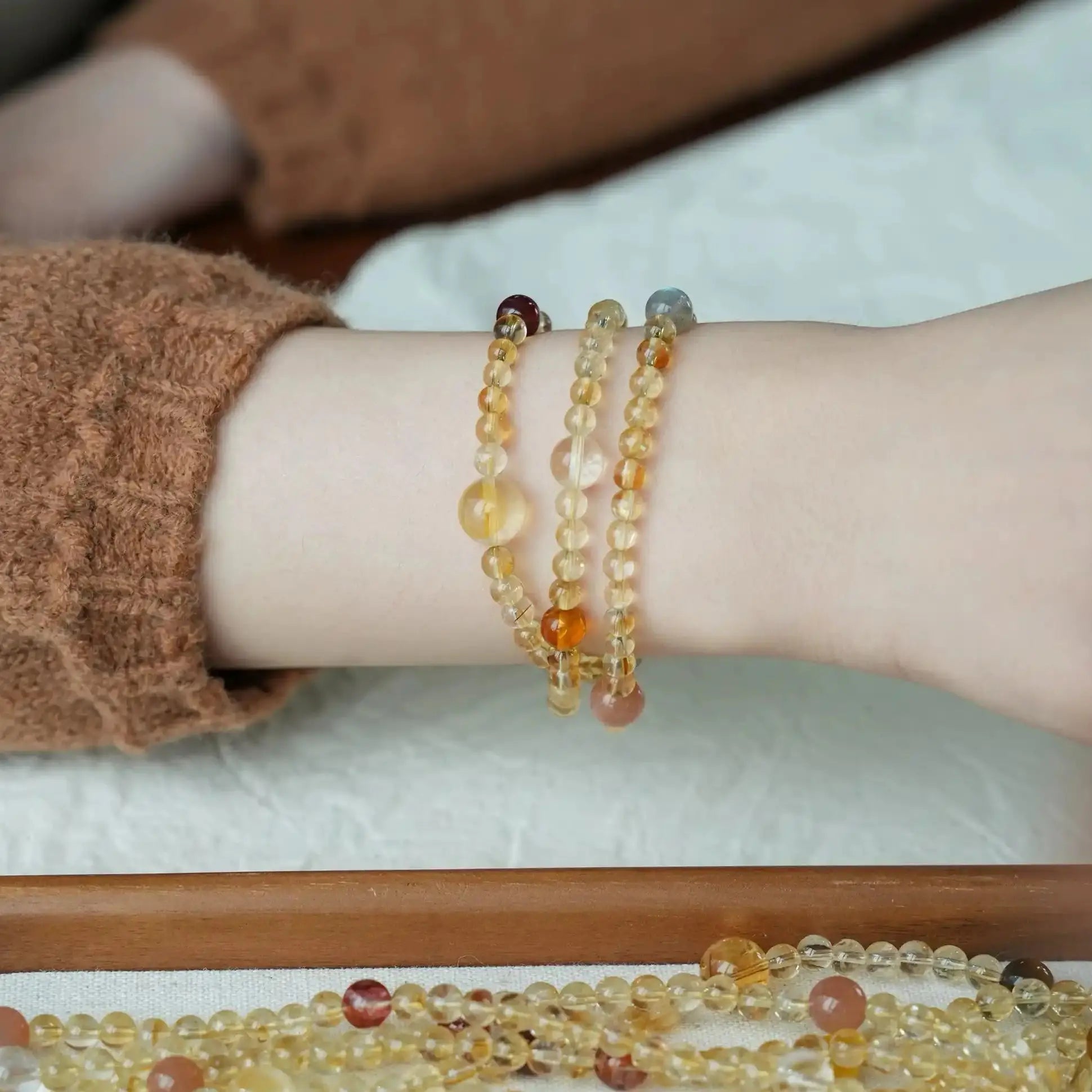 Model wearing a multi wrap citrine crystal bracelet, a layered crystal jewelry piece with warm tones.