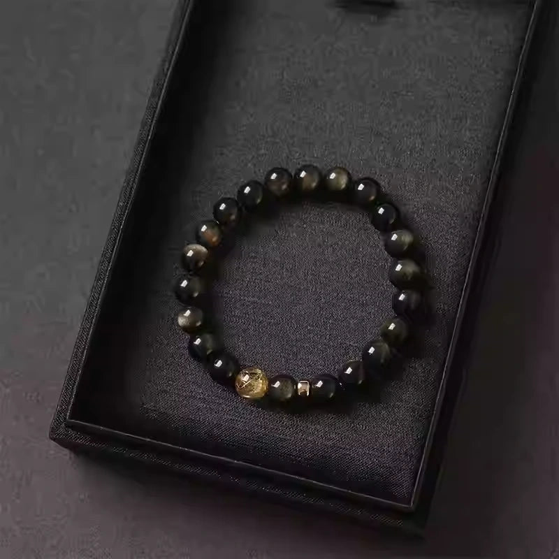 Handmade crystal bracelet highlighting contrast between dark gold obsidian and vibrant citrine center bead.