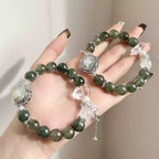Handmade green crystal bracelet with smooth natural quartz beads, layered for visual depth.