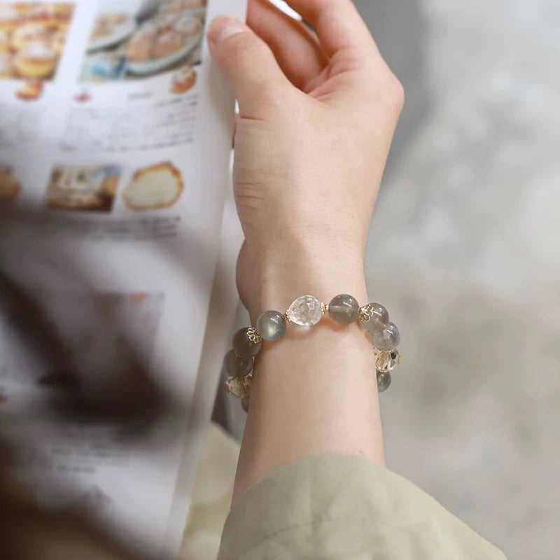 Model showcasing grey moonstone bracelet with gold sun charm, supporting emotional clarity, personal energy, and intuitive awareness.