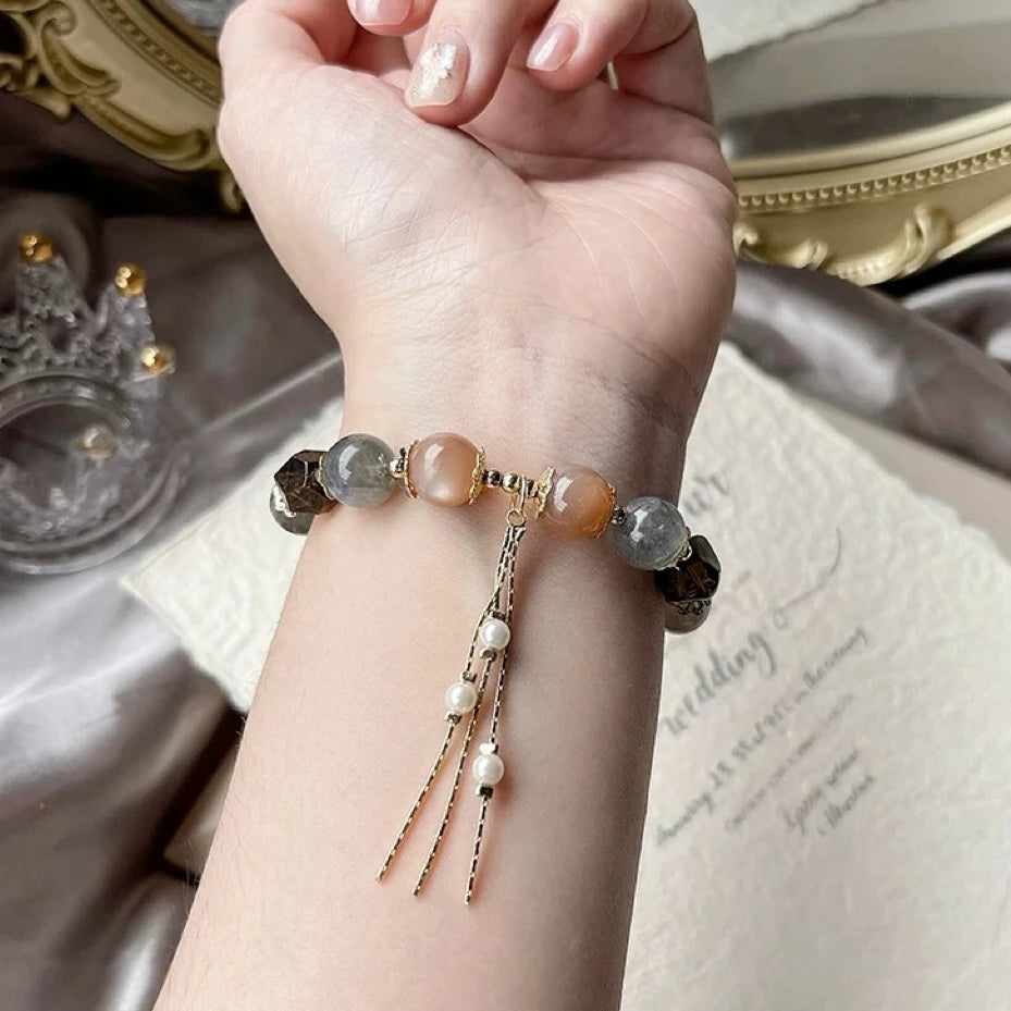Woman wearing grey and orange moonstone with smoky quartz bracelet for emotional balance, confidence, and grounding protection.