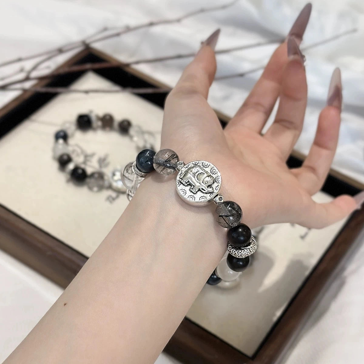 Black crystal bead bracelet with elephant charm, symbolizing wisdom, luck, and positive energy protection.