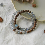 Natural gray moonstone paired with agarwood beads in a layered bracelet, radiating peaceful and grounding energy.