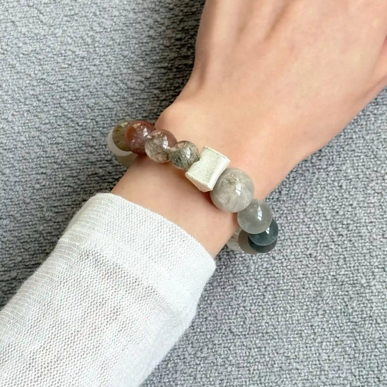 Wrist view of a rutilated quartz bracelet featuring natural phantom crystal details.