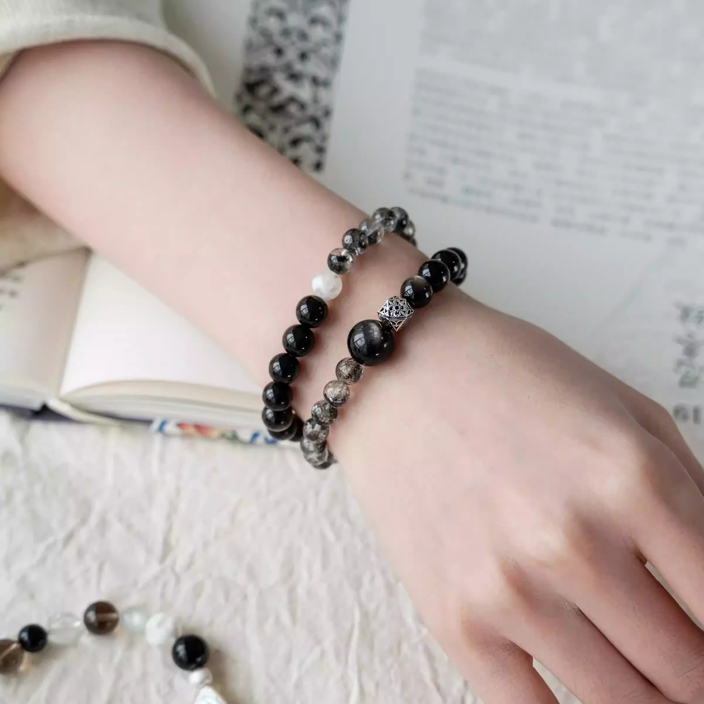 Model wearing a double wrap silver obsidian bracelet with a sleek, understated style.