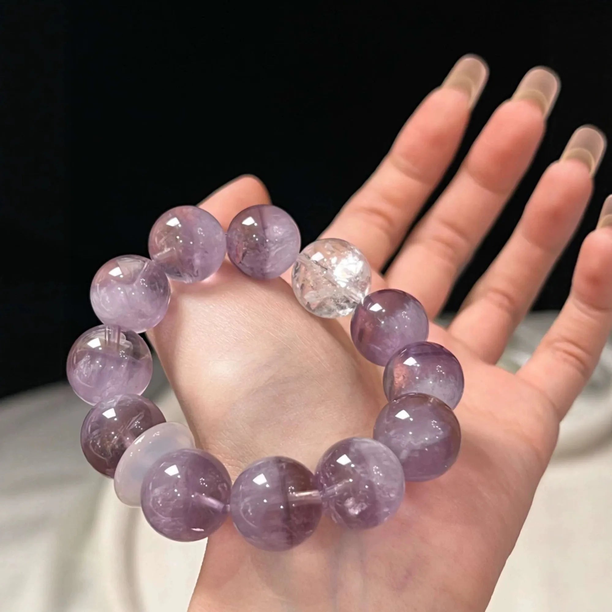 Close-up of amethyst and white phantom quartz bracelet, promoting mental clarity, intuition, and spiritual growth.