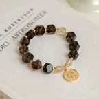 Modern smoky quartz bracelet with golden rutilated quartz beads for stability, prosperity, and energy balance.